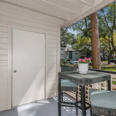 Outdoor covered patio with storage area at Willowbrooke Apartments in Lakeland